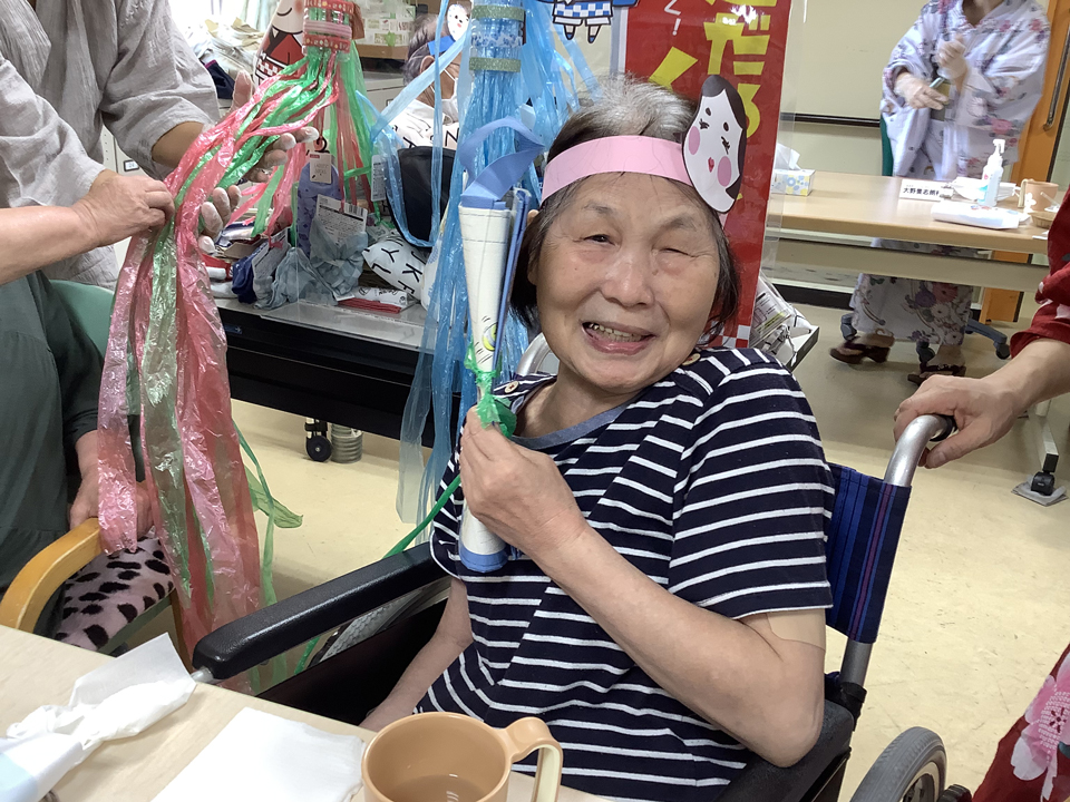 お楽しみ企画のひも引きで景品を当てる女性の利用者様の画像