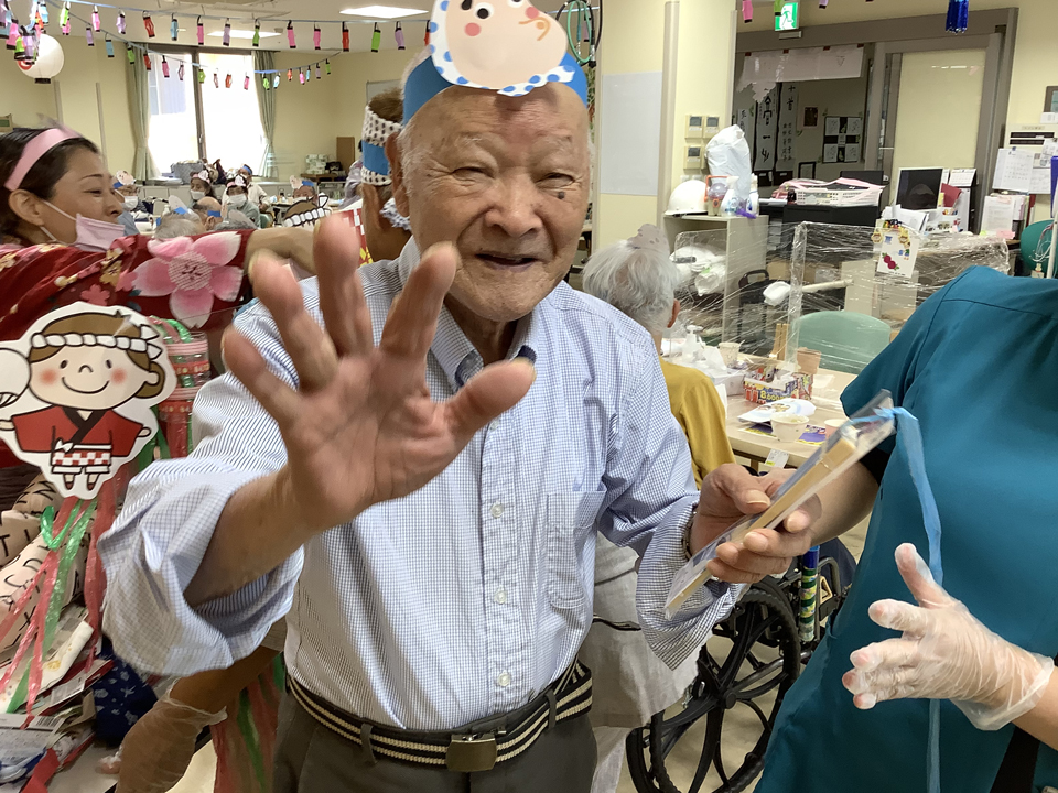 お楽しみ企画のひも引きで景品を当てる男性の利用者様の画像